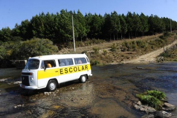 Ponte interditada obriga o motorista de uma kombi escolar a entrar em um rio com pedras Foto: Roni Rigon | Agencia RBS