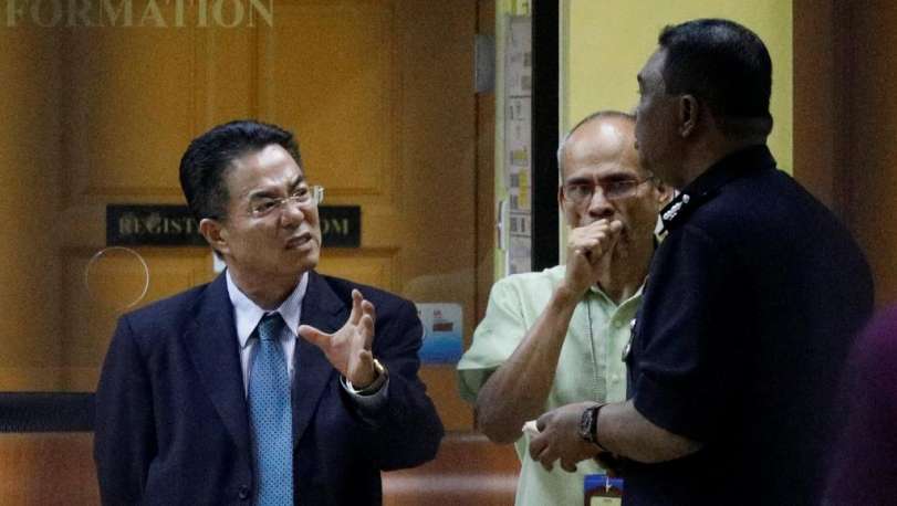 Um alto funcionário da Coreia do Norte na Malásia conversa com policiais diante do IML do Hospital de Kuala Lumpur, onde está o corpo de Kim Jong-nam.