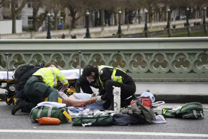 Paramédicos atendem uma pessoa ferida após incidente com tiros na ponte de Westminster em Londres