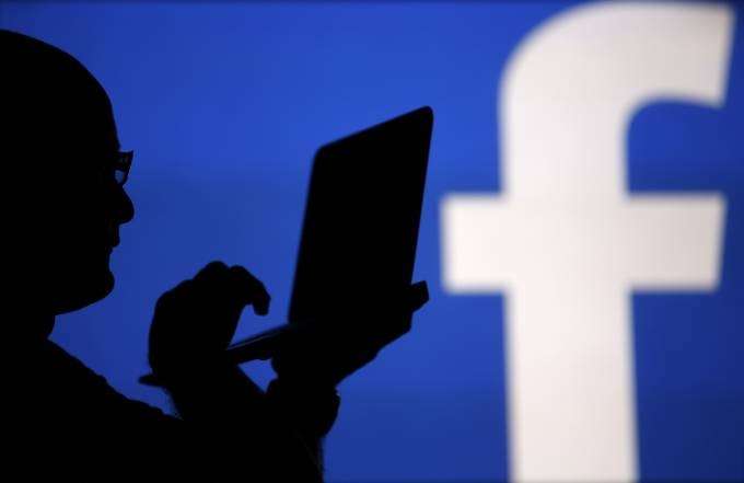Homens em frente a um logo do Facebook