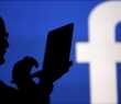 Homens em frente a um logo do Facebook